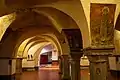 Interior of the Romanesque Crypt, with frescos of religious figures visible.