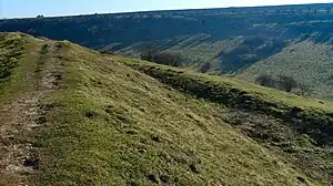 Iron Age rampart and outer ditch, with the dry valley in the background