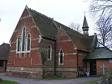 An angled view of a church, with a spire in the background