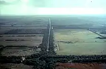 Aerial view of agricultural fields through the middle of which is a drainage canal