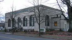 Photograph of the St. Johns Station, a rectangular, single-story building on its own block with tall, arched windows