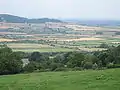 Fields at Stanley Pontlarge viewed from Langley Hill. Looking north to the Vale of Evesham. Note the steam train on the railway