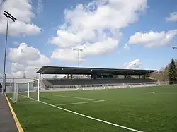 A modest stadium's grandstand over a soccer field