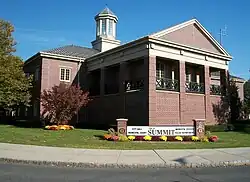 Picture of a modern brick two-story building with a steeple and a sign saying "Summit" City Hall