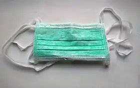 A surgical face mask, meant for single use. It is a type of the face masks often used to prevent the spread of Coronavirus. They are used in countries with coronavirus disease (COVID-19) outbreaks and are worn in hospitals as well as in public. They are not designed to protect the wearer from inhaling airborne bacteria or virus particles and are less effective than respirators, such as N95 or FFP masks.