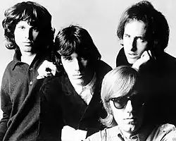 The Doors in 1966: Jim Morrison (left), John Densmore (center), Robby Krieger (right) and Ray Manzarek (seated)