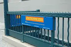 The entrance to the museum, a staircase with a green railing heading underground, at the corner of Boerum Place and Schermerhorn Street