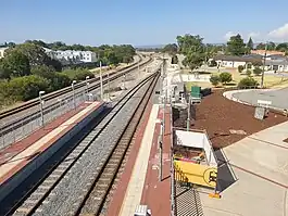 View from bridge of two railway tracks merging into one as they leave the station