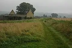 A roofless stone built barn in a rural landscape