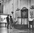 A man and a woman stand in front of a Torah ark.