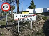 Town exit sign in Villarrubia de los Ojos, Ciudad Real, with a reassurance marker