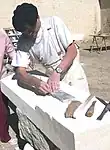 A French stonemason using a straightedge and chisels