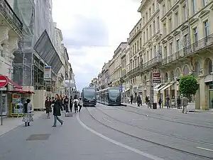 Trams on double-track in street surrounded by buildings