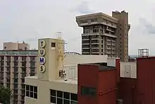 Upper part of beige and brick red manufacturing plant buildings