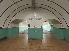 Two arched openings lead to two sloping tunnels, heading underneath the Tyne. The lower half of the walls are tiled green, the upper half with white and the floor a dark orange.