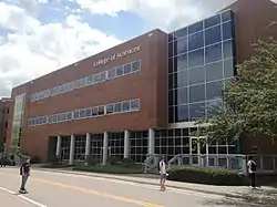 A brick and glass clad building is seen alongside a street.