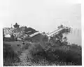 View from atop mountain down at the light station and pier – U.S. Coast Guard Archive