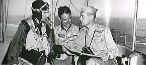 U.S. Navy Captain John S. Thach, commanding officer of Sicily, discusses a mission with two United States Marine Corps pilots from his ship while aboard Sicily off the Korean Peninsula during the Korean War.