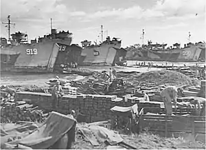 USS LST-919, LST-922, and LST-990 beached at Mindoro Island, Philippines, 15 December 1944, unloading supplies and equipment