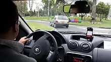 An Uber driver in Bogotá, Colombia with the Uber app on a dashboard-mounted smartphone