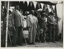 Four kings of Ugandan kingdoms, from left to right: The Omugabe of Ankole, Omukama of Bunyoro, the Kabaka of Buganda, and the Won Nyaci of Lango, at the signing of an agreement in Kabarole, Toro, Uganda, between the British governor, Sir Frederick Crawford  and the Omukama of Toro.