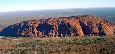 Uluru – a long, low mountain against a flat Australian plain