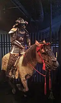 A re-creation of an armored samurai riding a horse, showing horse armour (uma yoroi or bagai)