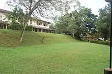 Large, sloping lawn with a building in the background