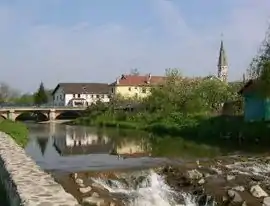 A view of the bridge crossing the river and the church tower, visible at the bottom right