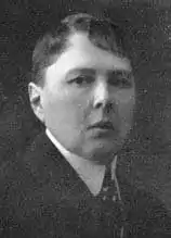 Black and white photograph of a woman with very short hair dressed in a man's suit and tie