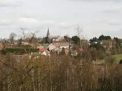 An image of the Viesville skyline; a church steeple and several small buildings are visible amid woods