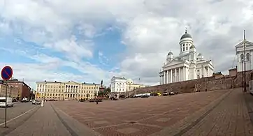 The red building on the left breaks the architectural style of the square