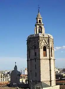 a view of a medieval bell tower from the roof of a nearby building