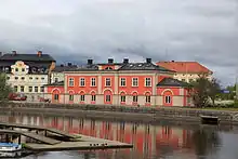 A three-storey, red-orange building on the waterfront