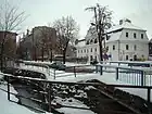 Pełcznica river and the historic Pod Lwami House ("Under the Lions") on the right, in wintertime