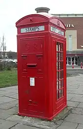 Post box incorporated into a Type K4 telephone kiosk, introduced in 1927. 10 survive in the UK of this design by Sir Giles Gilbert Scott which also incorporates two stamp vending machines. This red telephone box is in Warrington, Cheshire, England