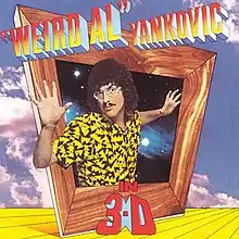 The cover for "Weird Al" Yankovic in 3-D shows "Weird Al" Yankovic protruding out of an askew box with a wooden frame. The title is written in mock three-deminsional font.