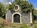 A well house above the Mourne Conduit near Ballynahinch and red access gate, now both listed.