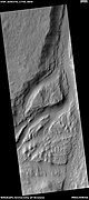 Streamlined feature in the Mangala Valles, as seen by HiRISE under the HiWish program. Many dark slope streaks are visible.  Location is Memnonia quadrangle.