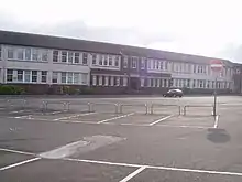 Partial view of two-storey school building and its main entrance