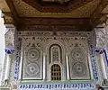 Decoration on the outer wall of the mausoleum, with a grilled window to the tomb (bottom center) where prayers can be offered to Idriss II