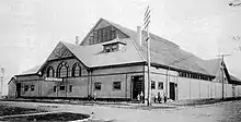 Exterior of wooden building with peaked roof and arched windows