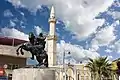 A statue of Saladin and mosque behind in the city center