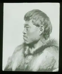 A Inuit man in a parka with a mustache looking to his right.